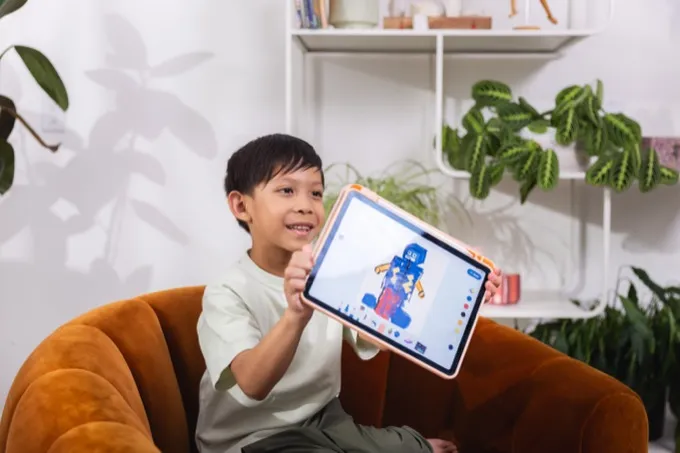 Boy proudly showing artwork on a tablet