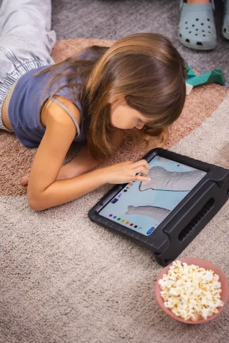 Girl drawing on a tablet at home