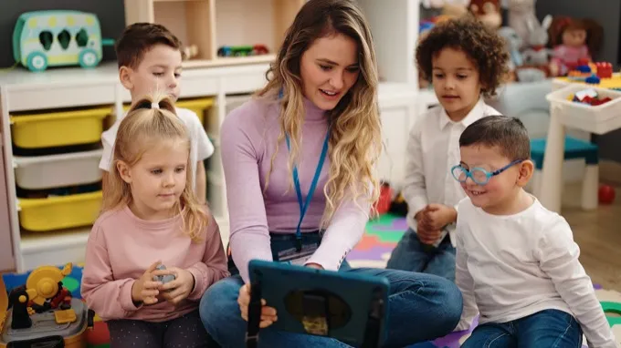 Teacher reading with preschool students on a tablet